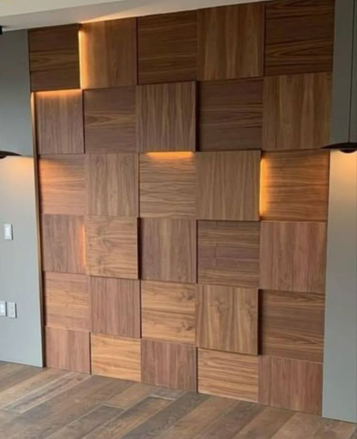 Detail panel dinding berbahan kayu solid dengan pola geometris 3D dan permainan kedalaman, dilengkapi pencahayaan aksen warm white yang menonjolkan tekstur dan kehangatan material.